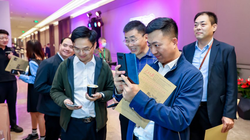 人民網(wǎng)研發(fā)推出的《人民日?qǐng)?bào)》生日?qǐng)?bào)吸引嘉賓體驗(yàn)。主辦方供圖